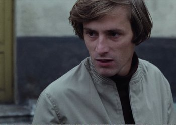 Movie still from “Camera Buff” (1979), directed by Krzysztof Kieslowski – A person wearing a jacket; Close Up shot, Low angle