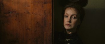 A woman standing in front of a wooden wall