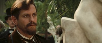 A man with a long beard and a monkey in the background