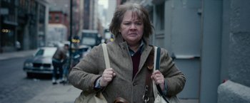 Movie still from “Can You Ever Forgive Me?” (2018), directed by Marielle Heller – A woman is walking down the street holding a bag; Close Up shot, Over the shoulder angle