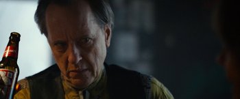 Movie still from “Can You Ever Forgive Me?” (2018), directed by Marielle Heller – An older man with a goatee looking at the camera; Close Up shot, Over the shoulder angle