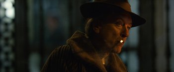 Movie still from “Can You Ever Forgive Me?” (2018), directed by Marielle Heller – An older man wearing a hat is smoking a cigarette; Close Up shot, Over the shoulder angle