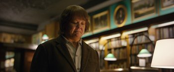 Movie still from “Can You Ever Forgive Me?” (2018), directed by Marielle Heller – A man in a brown jacket standing in front of a book shelf; Close Up shot, Low angle