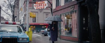 Movie still from “Can You Ever Forgive Me?” (2018), directed by Marielle Heller – A woman walking down the street holding an umbrella; Wide shot, Low angle