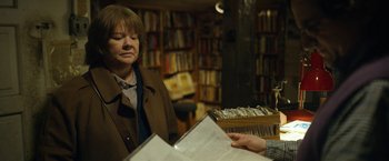 Movie still from “Can You Ever Forgive Me?” (2018), directed by Marielle Heller – A woman is looking at a book in a book store; Medium shot, Over the shoulder angle