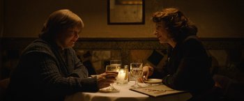 Movie still from “Can You Ever Forgive Me?” (2018), directed by Marielle Heller – Two people sitting at a table with a lit candle; Medium shot, High angle