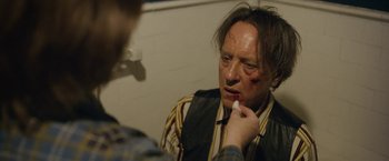 Movie still from “Can You Ever Forgive Me?” (2018), directed by Marielle Heller – A man with bruises on his face is looking in the mirror; Close Up shot, Over the shoulder angle