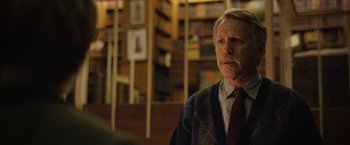 Movie still from “Can You Ever Forgive Me?” (2018), directed by Marielle Heller – An older man wearing a sweater and tie in a library; Close Up shot, Low angle
