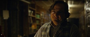 Movie still from “Can You Ever Forgive Me?” (2018), directed by Marielle Heller – A man with glasses is standing in a room; Close Up shot, Over the shoulder angle