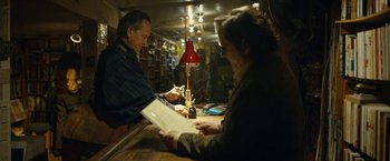 Movie still from “Can You Ever Forgive Me?” (2018), directed by Marielle Heller – A man and a woman in a library looking at papers; Medium shot, Low angle