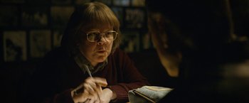 Movie still from “Can You Ever Forgive Me?” (2018), directed by Marielle Heller – An older woman sitting at a table with a pen in her hand; Close Up shot, Over the shoulder angle