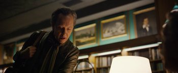 Movie still from “Can You Ever Forgive Me?” (2018), directed by Marielle Heller – A man standing in front of a lamp in a room; Medium shot, Low angle