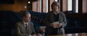 Movie still from “Can You Ever Forgive Me?” (2018), directed by Marielle Heller – Two people in suits are sitting at a table; Medium shot, Over the shoulder angle