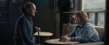 Movie still from “Can You Ever Forgive Me?” (2018), directed by Marielle Heller – Two people sitting at a table talking to each other; Medium shot, Over the shoulder angle