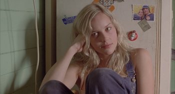 Movie still from “Candy” (2006), directed by Neil Armfield – A woman sitting in front of a refrigerator with her hand on her head; Close Up shot, Low angle