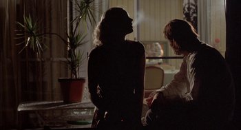 Movie still from “Candy” (2006), directed by Neil Armfield – Two people are standing in a room with a plant; Medium shot, Over the shoulder angle