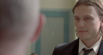 Movie still from “Candy” (2006), directed by Neil Armfield – A woman in a black suit looking into a mirror; Close Up shot, Over the shoulder angle