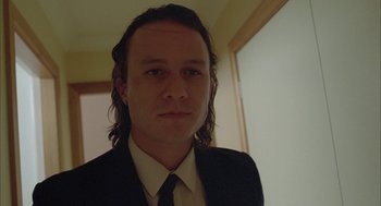 Movie still from “Candy” (2006), directed by Neil Armfield – A man with long hair wearing a suit and tie; Close Up shot, Low angle