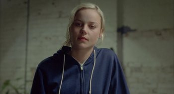 Movie still from “Candy” (2006), directed by Neil Armfield – A young woman with blonde hair wearing a blue hoodie; Close Up shot, Over the shoulder angle