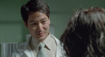 Movie still from “Candy” (2006), directed by Neil Armfield – A man in a white shirt and a green neck tie; Close Up shot, Over the shoulder angle