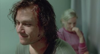 Movie still from “Candy” (2006), directed by Neil Armfield – A person with blood on his face; Close Up shot, Over the shoulder angle