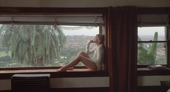 Movie still from “Candy” (2006), directed by Neil Armfield – A woman sitting on top of a window sill; Wide shot, Low angle