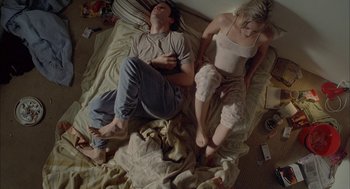 Movie still from “Candy” (2006), directed by Neil Armfield – A man and a woman sleeping on a bed; Wide shot, Overhead angle