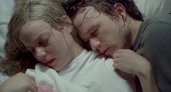 Movie still from “Candy” (2006), directed by Neil Armfield – A man and a woman laying in a bed together; Close Up shot, Overhead angle