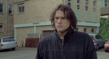 Movie still from “Candy” (2006), directed by Neil Armfield – A man with long hair and a black jacket; Close Up shot, Low angle