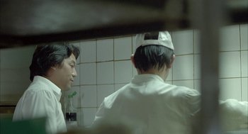 Movie still from “Candy” (2006), directed by Neil Armfield – Two men in white shirts and hats in a kitchen; Close Up shot, Over the shoulder angle