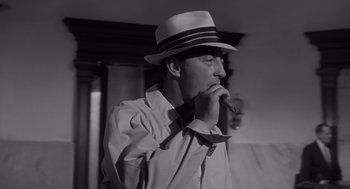 Movie still from “Cape Fear” (1962), directed by J. Lee Thompson – A black and white photo of a man smoking a pipe; Close Up shot, Low angle