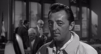 Movie still from “Cape Fear” (1962), directed by J. Lee Thompson – A black - and - white photo of a man in a crowd; Close Up shot, Over the shoulder angle