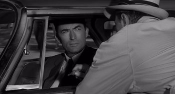 Movie still from “Cape Fear” (1962), directed by J. Lee Thompson – A black - and - white photo of a man in a car; Close Up shot, Over the shoulder angle