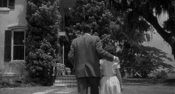 Movie still from “Cape Fear” (1962), directed by J. Lee Thompson – A man and a woman walking in front of a house; Medium shot, Low angle