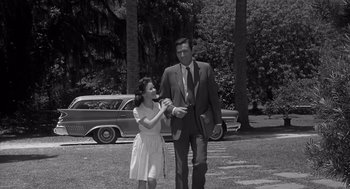 Movie still from “Cape Fear” (1962), directed by J. Lee Thompson – A man and a woman are walking in a park; Wide shot, Low angle