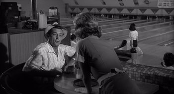 Movie still from “Cape Fear” (1962), directed by J. Lee Thompson – A man and a woman sitting at a table in a restaurant; Medium shot, Low angle