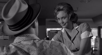 Movie still from “Cape Fear” (1962), directed by J. Lee Thompson – A woman smiles at a man wearing a hat; Close Up shot, Over the shoulder angle