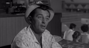 Movie still from “Cape Fear” (1962), directed by J. Lee Thompson – A black and white photo of a man wearing a hat; Close Up shot, Over the shoulder angle