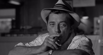 Movie still from “Cape Fear” (1962), directed by J. Lee Thompson – A black and white photo of a man smoking a cigar; Close Up shot, Low angle