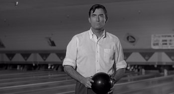 Movie still from “Cape Fear” (1962), directed by J. Lee Thompson – A black and white photo of a man holding a bowling ball; Close Up shot, Low angle