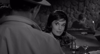Movie still from “Cape Fear” (1962), directed by J. Lee Thompson – A woman sitting at a table with a man in the background; Close Up shot, Over the shoulder angle