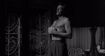 Movie still from “Cape Fear” (1962), directed by J. Lee Thompson – A man standing in front of an ornate iron gate; Medium shot, Low angle