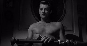 Movie still from “Cape Fear” (1962), directed by J. Lee Thompson – A man with no shirt is posing for a picture; Medium shot, Low angle