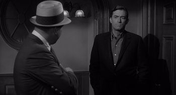 Movie still from “Cape Fear” (1962), directed by J. Lee Thompson – A man standing next to another man in a suit; Medium shot, Over the shoulder angle