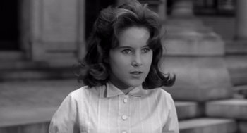 Movie still from “Cape Fear” (1962), directed by J. Lee Thompson – A young girl in a white shirt is looking at the camera; Close Up shot, High angle