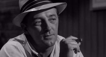 Movie still from “Cape Fear” (1962), directed by J. Lee Thompson – A black and white photo of a man smoking a cigarette; Close Up shot, Low angle