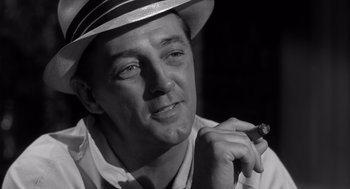 A black and white photo of a man with a hat and a cigar