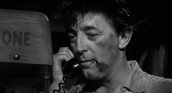 Movie still from “Cape Fear” (1962), directed by J. Lee Thompson – A black and white photo of a man talking on a phone; Close Up shot, Low angle
