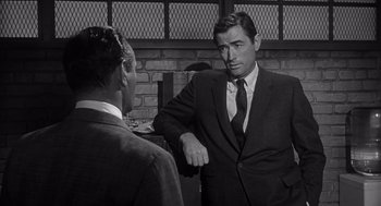 Movie still from “Cape Fear” (1962), directed by J. Lee Thompson – A man in a suit talking to another man in a suit; Medium shot, Over the shoulder angle