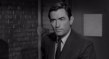Movie still from “Cape Fear” (1962), directed by J. Lee Thompson – Black and white photograph of a man wearing a suit and tie; Close Up shot, Over the shoulder angle